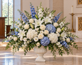 Heavenly Comfort blue and white premium sympathy floral arrangement with blue delphinium and hydrangea and white lilies in tall white urn