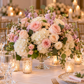 Pink and ivory rose centerpiece with white hydrangeas in clear glass compote on an elegant candlelit wedding reception table